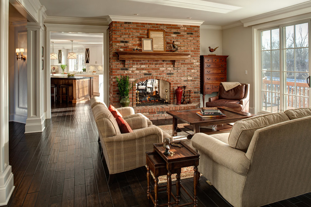 Cette photo montre une salle de séjour chic avec un mur beige, une cheminée double-face et un manteau de cheminée en brique.
