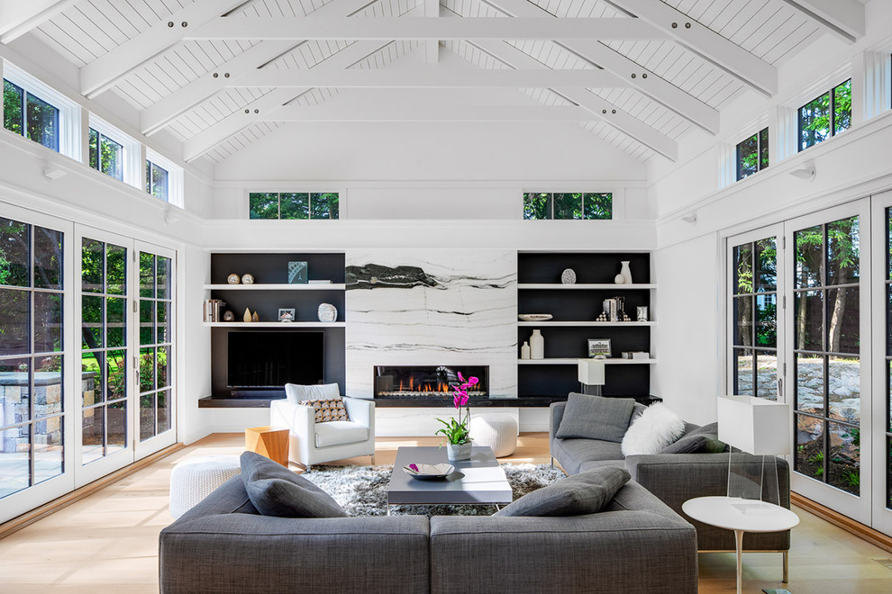 Modernes Wohnzimmer mit weißer Wandfarbe, hellem Holzboden, Gaskamin, Kaminumrandung aus Stein, Multimediawand und beigem Boden in Boston