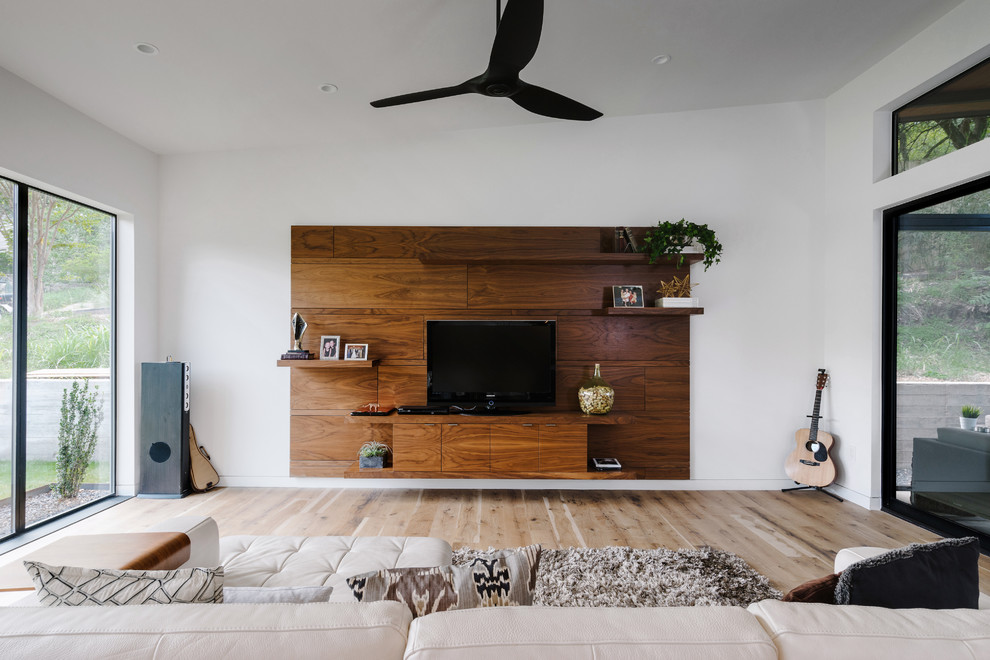 Идея дизайна: открытая гостиная комната в современном стиле с белыми стенами, светлым паркетным полом, отдельно стоящим телевизором и акцентной стеной без камина