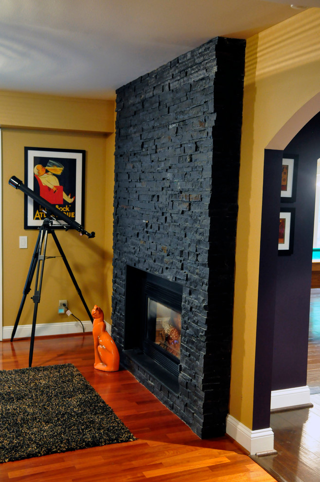 Стильный дизайн: открытая гостиная комната среднего размера в современном стиле с желтыми стенами, паркетным полом среднего тона, стандартным камином и фасадом камина из камня без телевизора - последний тренд