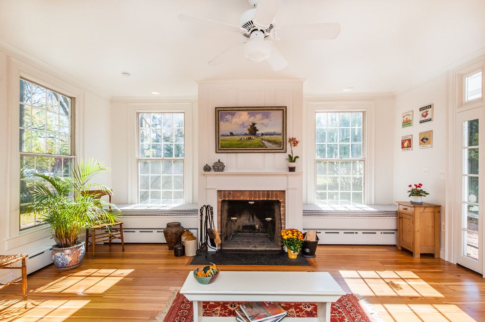 Inspiration for a mid-sized craftsman enclosed medium tone wood floor family room remodel in DC Metro with beige walls, a standard fireplace, a wood fireplace surround and a tv stand