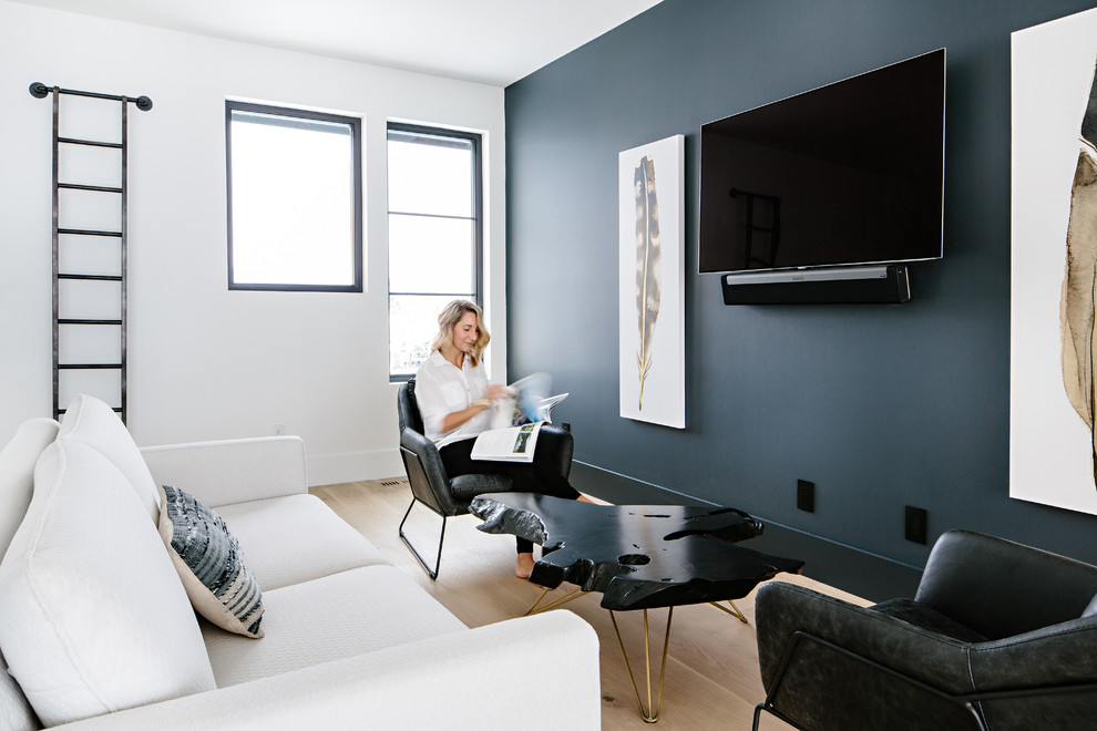 Foto de sala de estar tipo loft actual con paredes azules, suelo de madera clara, televisor colgado en la pared y suelo blanco