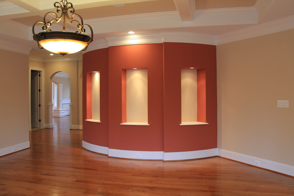 Idée de décoration pour une grande salle de séjour tradition avec un mur rouge, un sol en bois brun, une cheminée standard et un manteau de cheminée en bois.