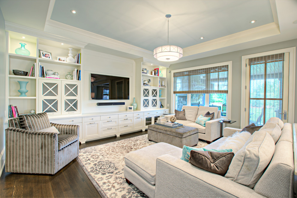 Imagen de sala de estar tradicional renovada con paredes grises, suelo de madera oscura, pared multimedia y alfombra