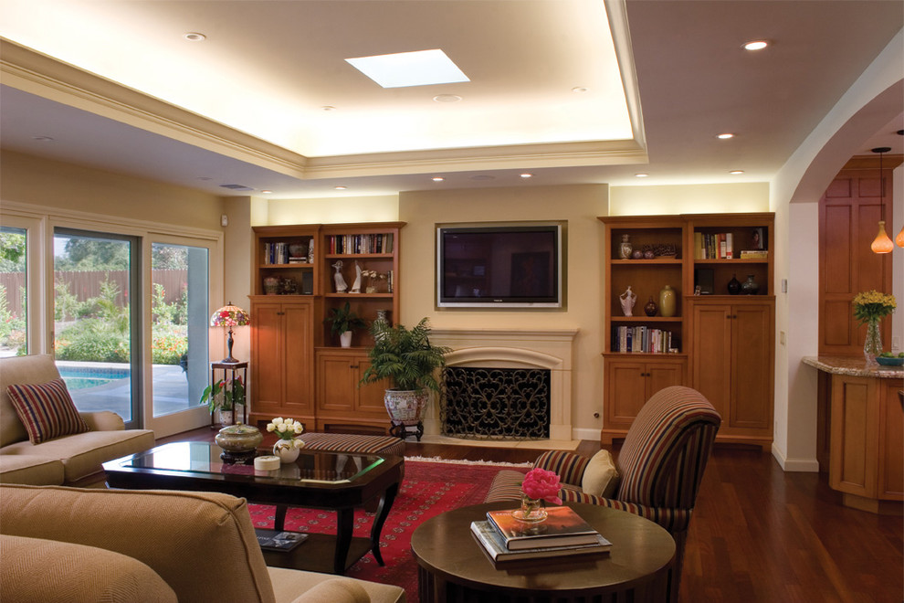 Example of a classic open concept dark wood floor family room design in Los Angeles with beige walls, a standard fireplace and a wall-mounted tv
