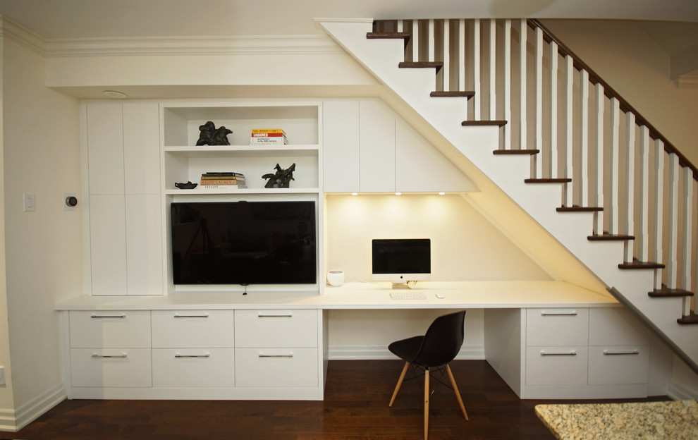 Modelo de sala de estar abierta contemporánea pequeña sin chimenea con suelo de madera en tonos medios, pared multimedia y paredes blancas