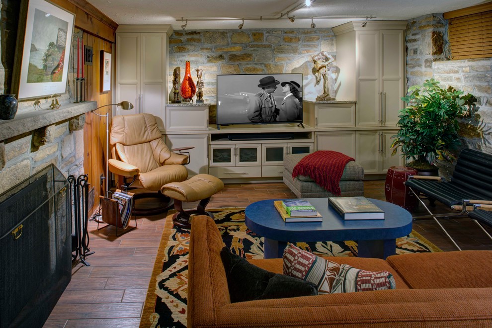 Cette photo montre une grande salle de séjour éclectique fermée avec un bar de salon, un sol en carrelage de porcelaine, une cheminée standard, un manteau de cheminée en pierre, un téléviseur indépendant et un sol marron.