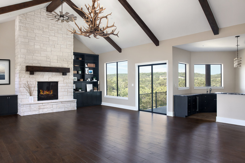 Inspiration for a large classic games room in Austin with a game room, grey walls, dark hardwood flooring, a standard fireplace, a stone fireplace surround, a built-in media unit, brown floors and exposed beams.