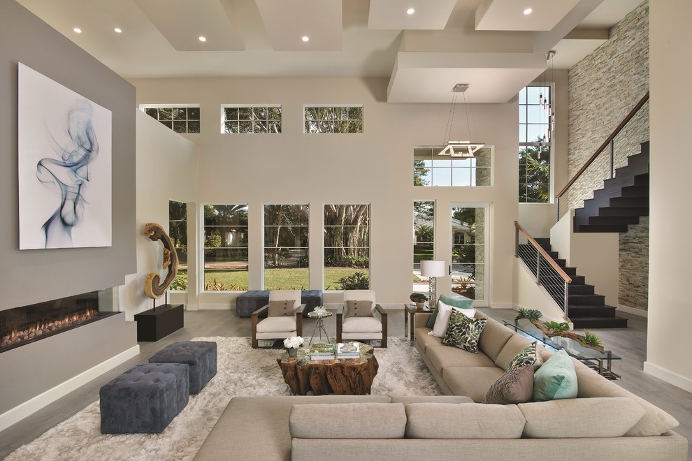 Large contemporary open plan games room in Miami with white walls, medium hardwood flooring, a ribbon fireplace and a plastered fireplace surround.