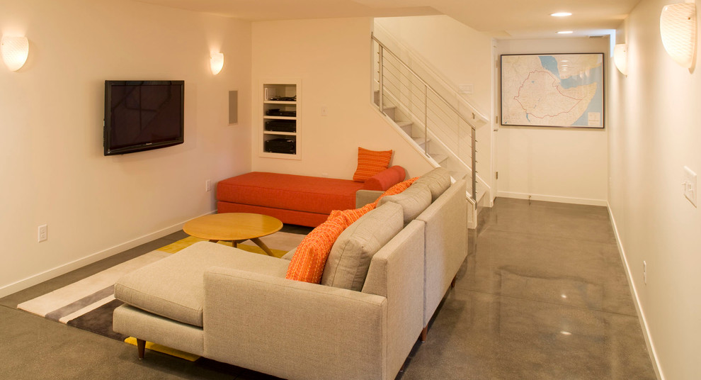 Idee per un soggiorno minimalista aperto con pavimento in cemento e TV a parete