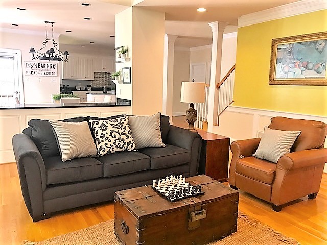Cette image montre une salle de séjour traditionnelle de taille moyenne et ouverte avec un mur jaune, un sol en bois brun et un sol marron.