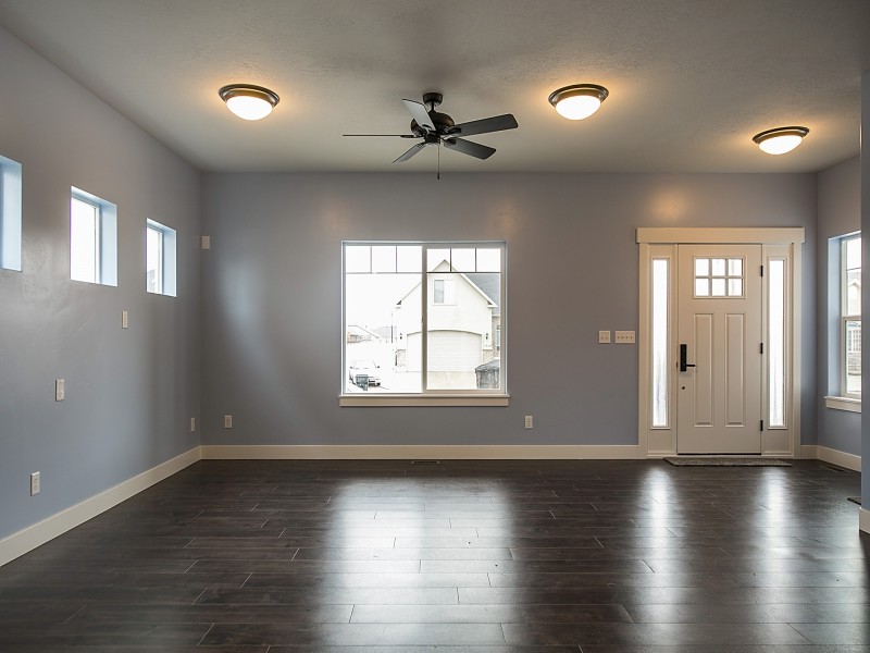 Foto de sala de estar abierta de estilo americano grande con suelo de madera en tonos medios y paredes grises