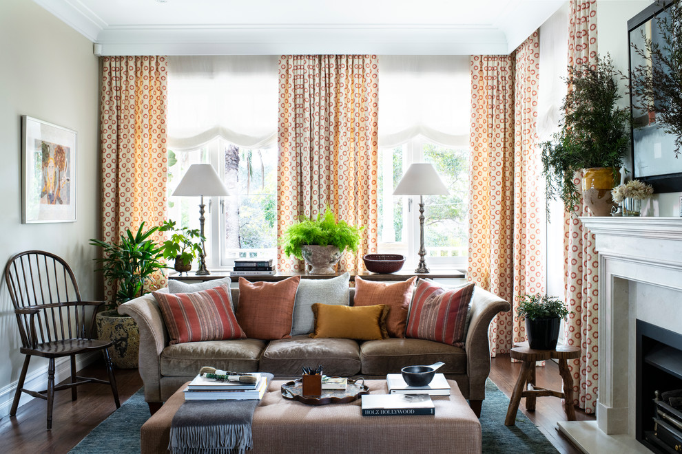 Idee per un soggiorno classico con pareti beige, pavimento in legno massello medio, camino classico e pavimento marrone