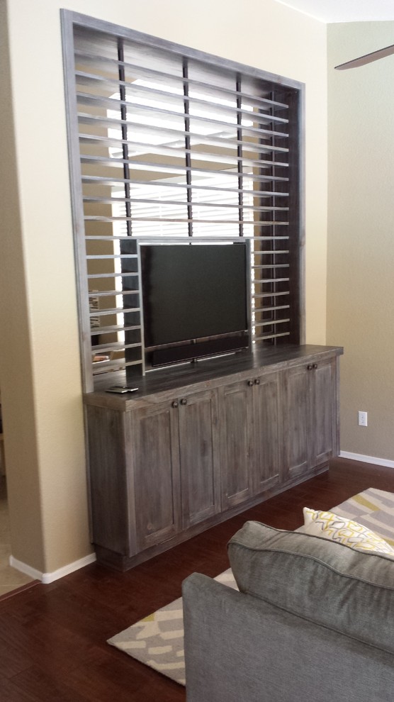 Inspiration for a large rustic enclosed family room remodel in Phoenix with a media wall