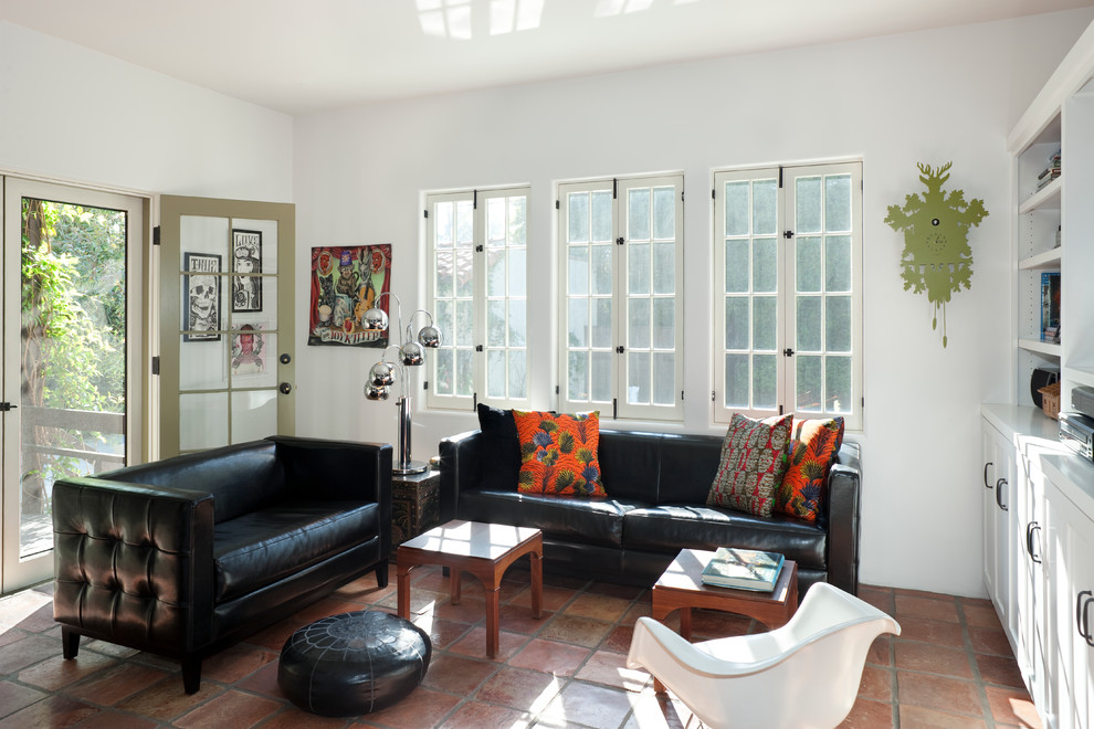 На фото: изолированная гостиная комната среднего размера в современном стиле с белыми стенами и полом из терракотовой плитки с