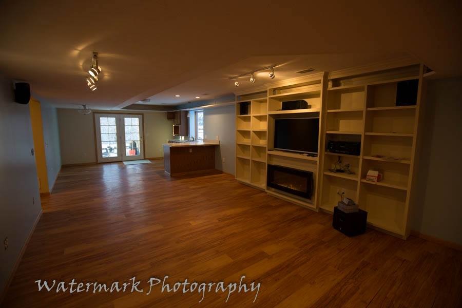 Diseño de sala de estar abierta tradicional de tamaño medio con paredes azules, suelo de madera clara, todas las chimeneas y marco de chimenea de madera
