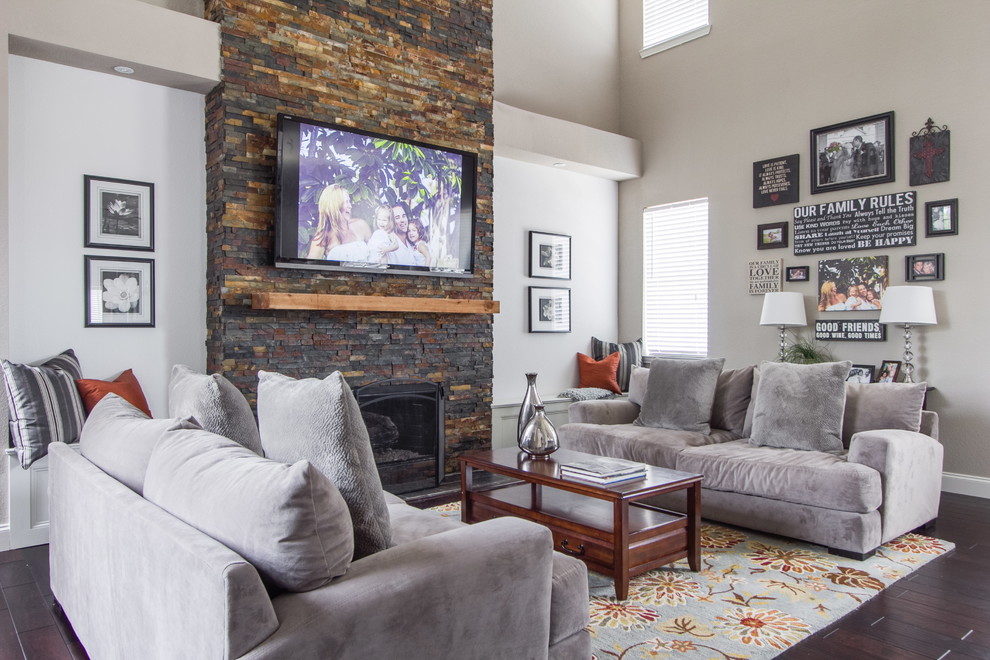 Ejemplo de sala de estar abierta clásica de tamaño medio con suelo de madera en tonos medios, todas las chimeneas, marco de chimenea de piedra y televisor colgado en la pared