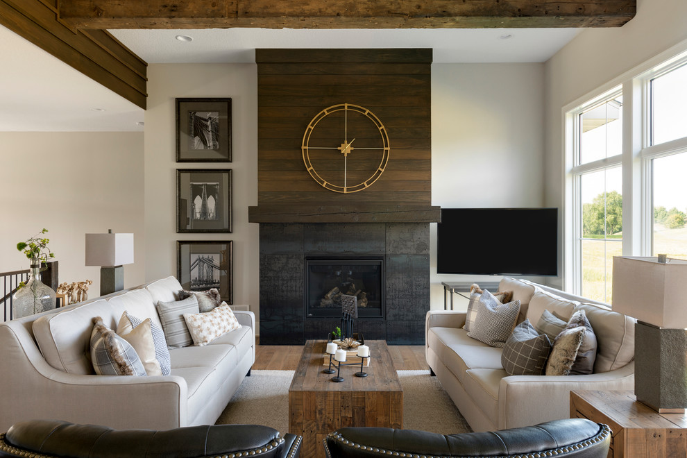 Foto di un soggiorno chic con pareti grigie, pavimento in legno massello medio, camino classico e TV a parete