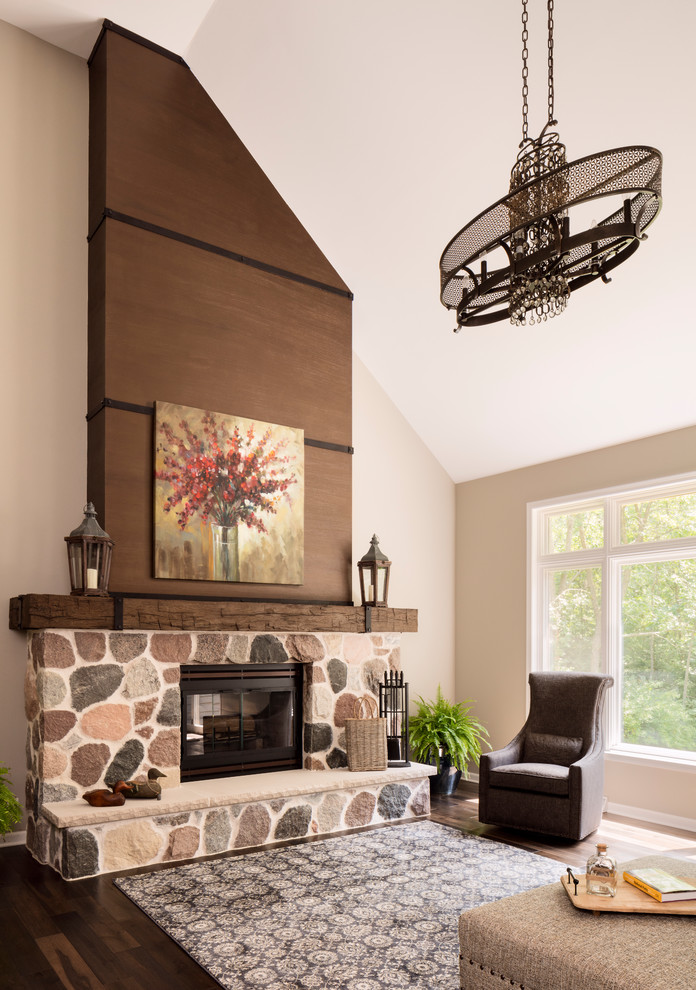 Inspiration for a medium sized classic enclosed games room in Milwaukee with beige walls, dark hardwood flooring, a standard fireplace, a stone fireplace surround, no tv and brown floors.