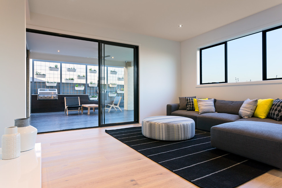 Cette image montre une salle de séjour design de taille moyenne et ouverte avec un mur blanc, parquet clair et un téléviseur indépendant.