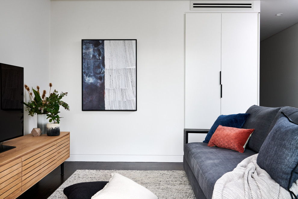 Idée de décoration pour une petite salle de séjour nordique fermée avec un mur blanc, parquet foncé, un téléviseur indépendant et un sol marron.