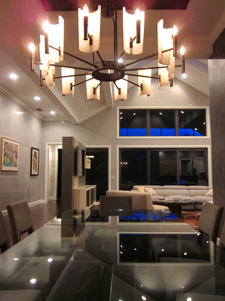 Пример оригинального дизайна: огромная открытая гостиная комната в современном стиле с серыми стенами, темным паркетным полом и отдельно стоящим телевизором