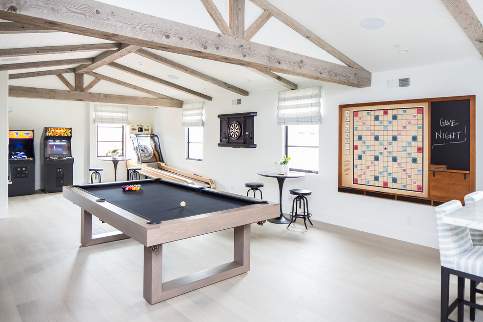 Aménagement d'une grande salle de séjour méditerranéenne ouverte avec salle de jeu, un mur blanc, parquet clair et un téléviseur fixé au mur.