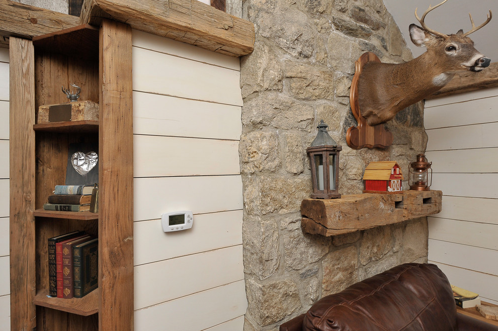 Imagen de sala de estar cerrada rural de tamaño medio con paredes beige, suelo de madera oscura y televisor colgado en la pared