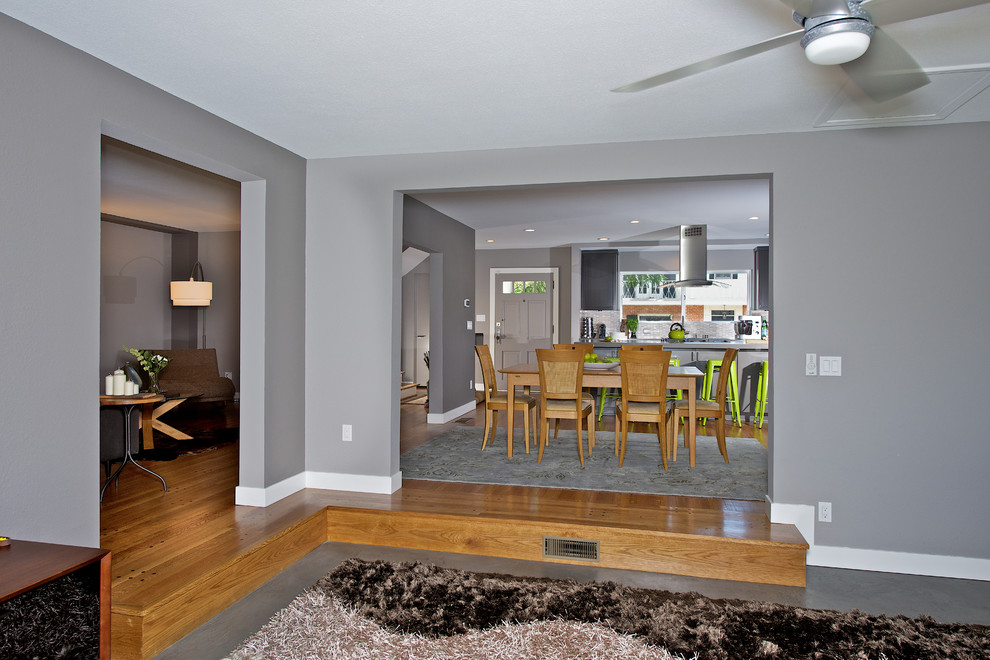 Example of a mid-sized trendy concrete floor family room design in San Diego with gray walls