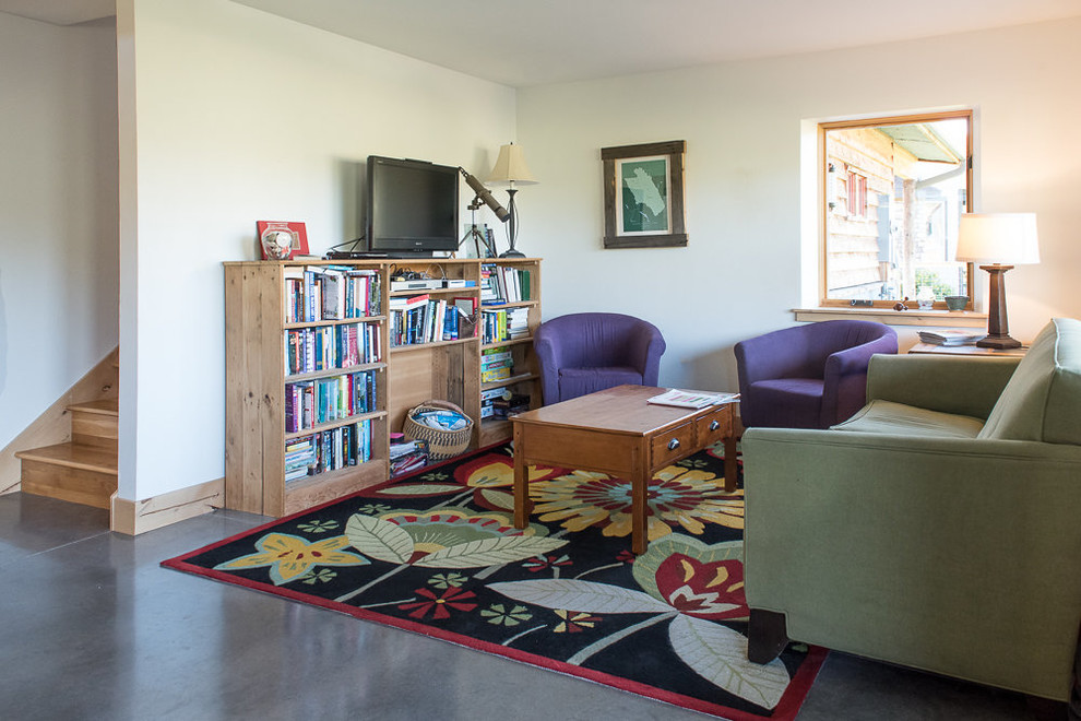 На фото: маленькая изолированная гостиная комната в стиле неоклассика (современная классика) с белыми стенами, бетонным полом, отдельно стоящим телевизором и серым полом без камина для на участке и в саду