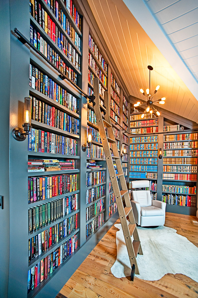 Immagine di un soggiorno classico di medie dimensioni con libreria, pavimento in legno massello medio, pavimento marrone e pareti grigie