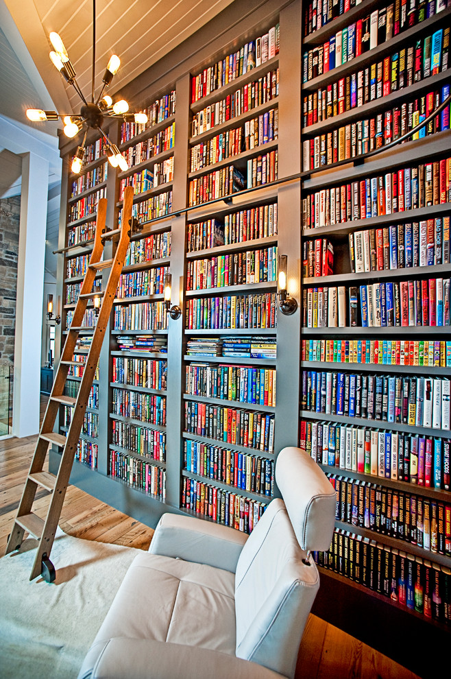 Idee per un soggiorno chic di medie dimensioni con libreria, pareti grigie, pavimento in legno massello medio e pavimento marrone
