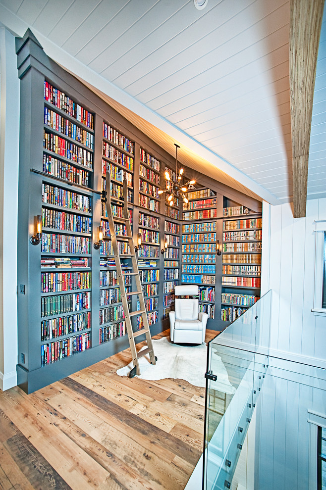 Esempio di un soggiorno chic di medie dimensioni con libreria, pareti grigie, pavimento in legno massello medio e pavimento marrone