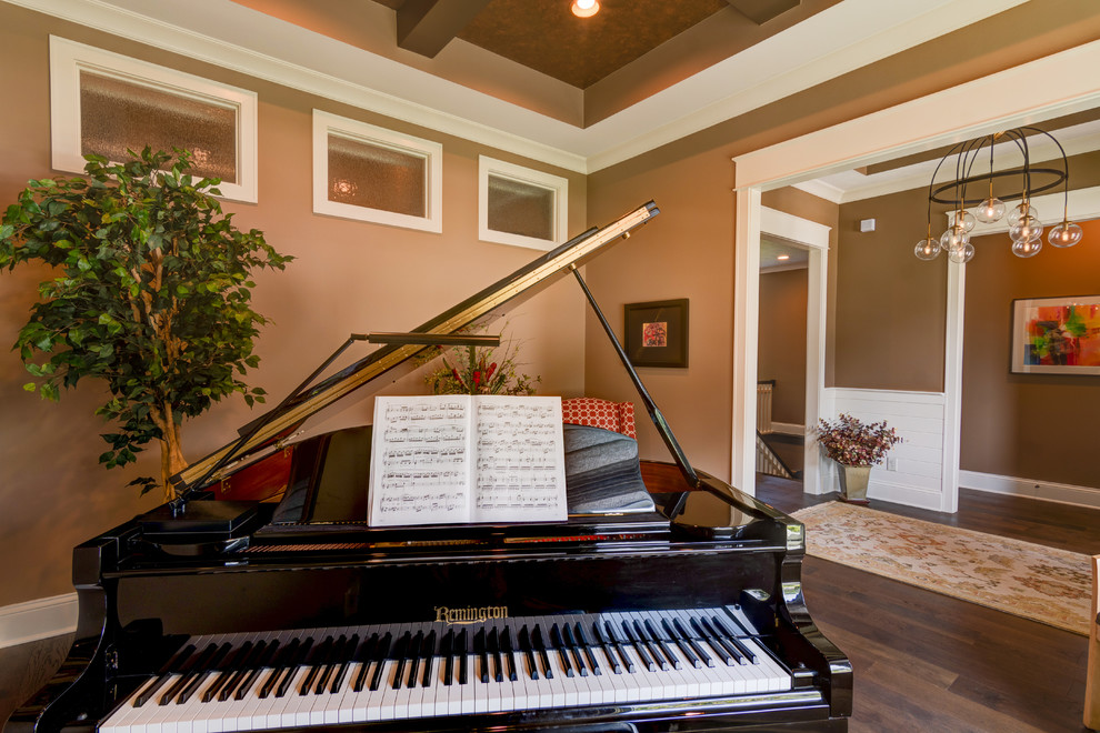 Example of a mid-sized arts and crafts open concept dark wood floor and brown floor family room design in Indianapolis with a music area, orange walls, no fireplace and no tv