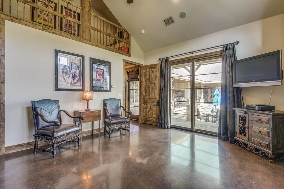 Mittelgroßes, Abgetrenntes Uriges Wohnzimmer ohne Kamin mit beiger Wandfarbe, Betonboden, Eck-TV und braunem Boden in Austin