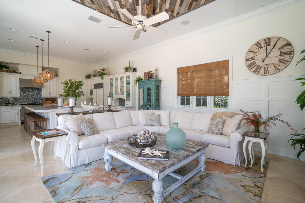Immagine di un grande soggiorno costiero aperto con pavimento in marmo, pavimento beige e pareti beige