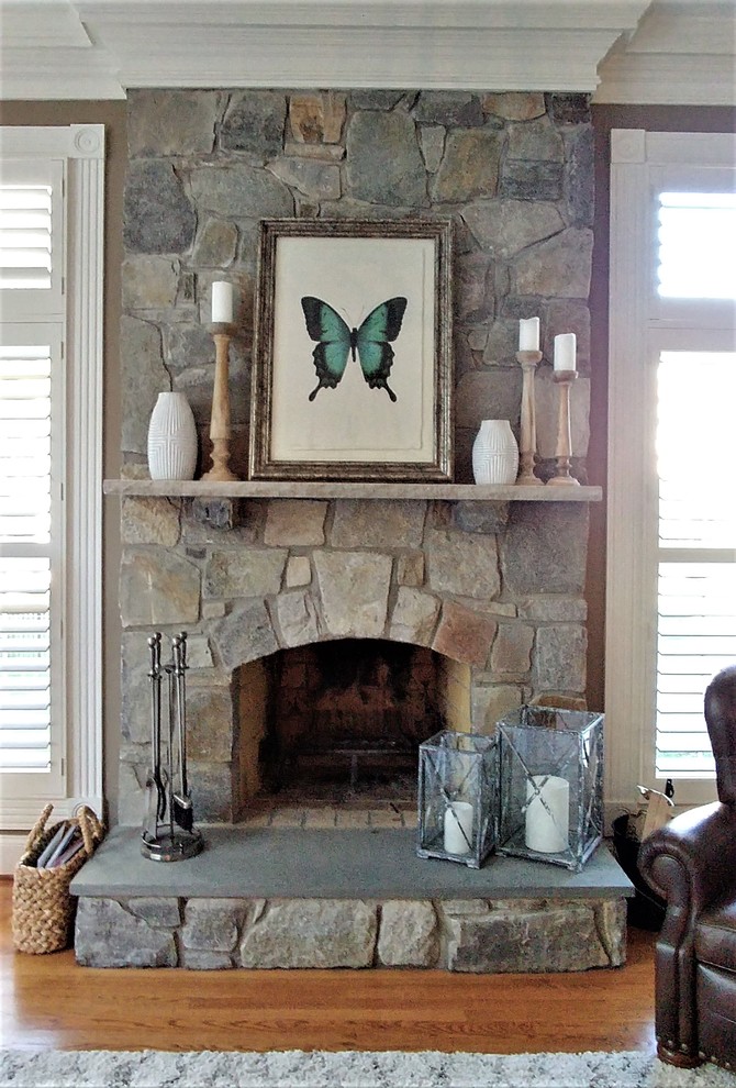 ワシントンD.C.にあるお手頃価格の広いラスティックスタイルのおしゃれなLDK (グレーの壁、無垢フローリング、標準型暖炉、石材の暖炉まわり、コーナー型テレビ) の写真