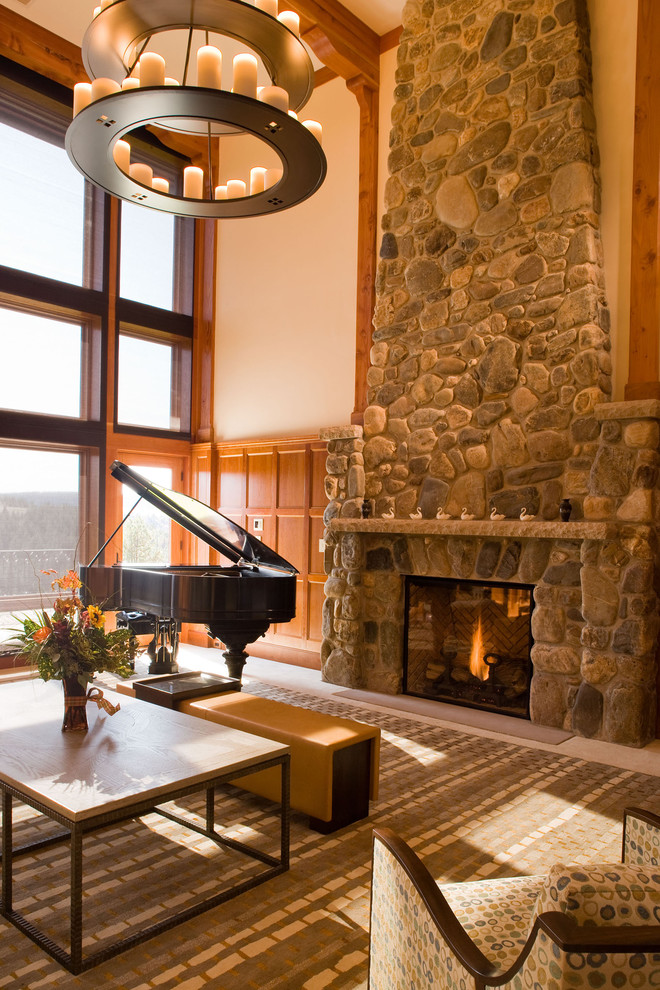 Example of a mountain style family room design in Santa Barbara with a music area, beige walls, a standard fireplace, a stone fireplace and no tv