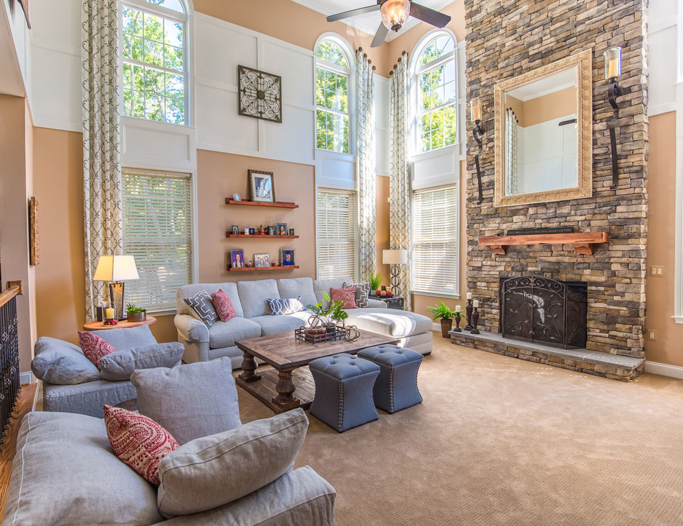 Ejemplo de sala de estar abierta clásica renovada grande con paredes beige, moqueta, todas las chimeneas, marco de chimenea de piedra y televisor colgado en la pared