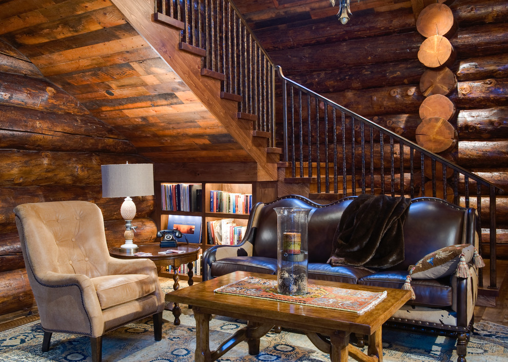 Cette photo montre une salle de séjour montagne avec une bibliothèque ou un coin lecture, un mur marron, parquet foncé et éclairage.