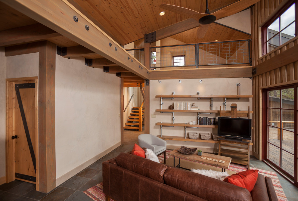 Imagen de sala de estar abierta rural sin chimenea con paredes beige y televisor independiente