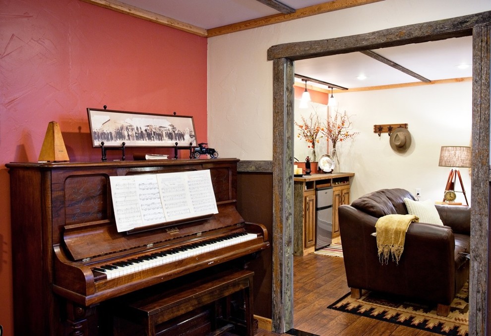 Cette photo montre une salle de séjour chic avec une salle de musique, un mur rouge et un sol en bois brun.