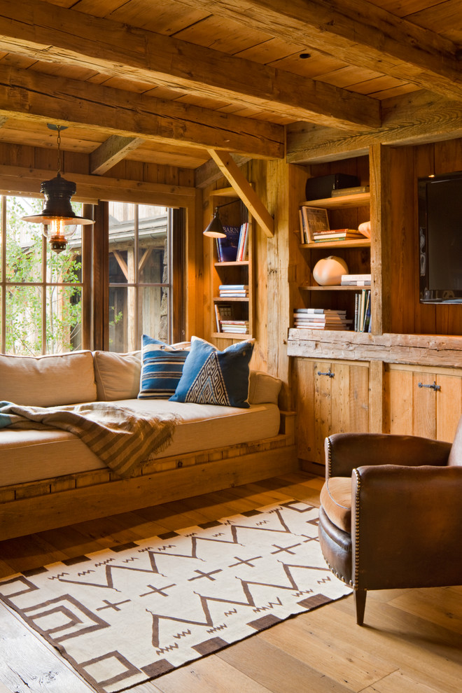 Foto de sala de estar rural con suelo de madera en tonos medios y televisor colgado en la pared