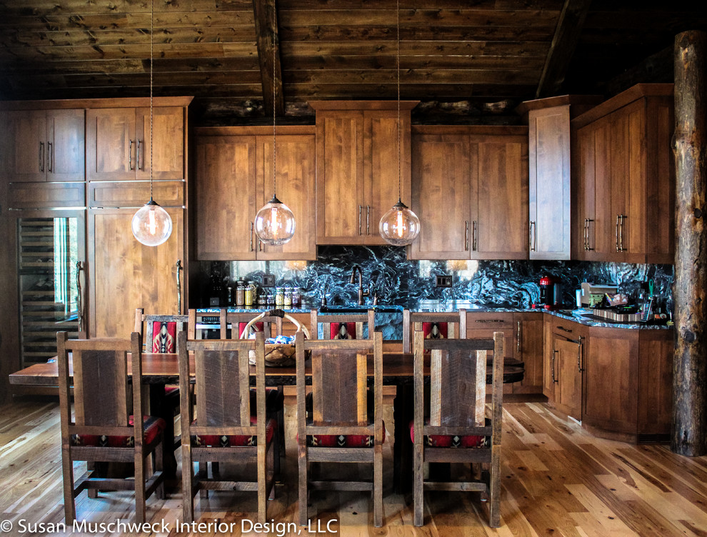 This is an example of a medium sized rustic open plan games room in Other with medium hardwood flooring, a standard fireplace, a home bar, brown walls and a stone fireplace surround.