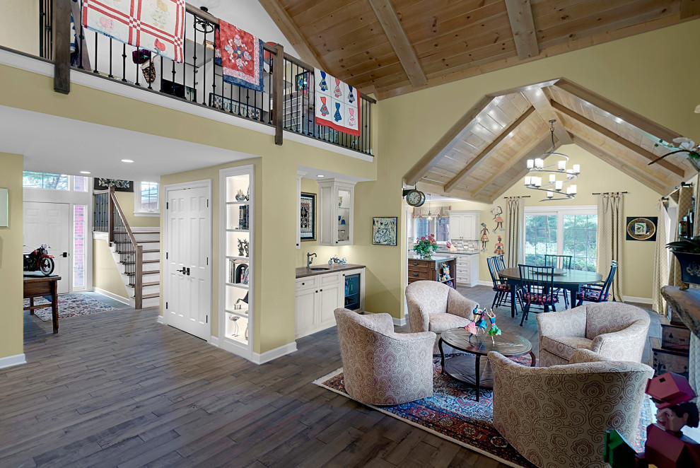 Foto di un grande soggiorno stile rurale aperto con angolo bar, pareti gialle, parquet scuro, pavimento marrone e soffitto a volta
