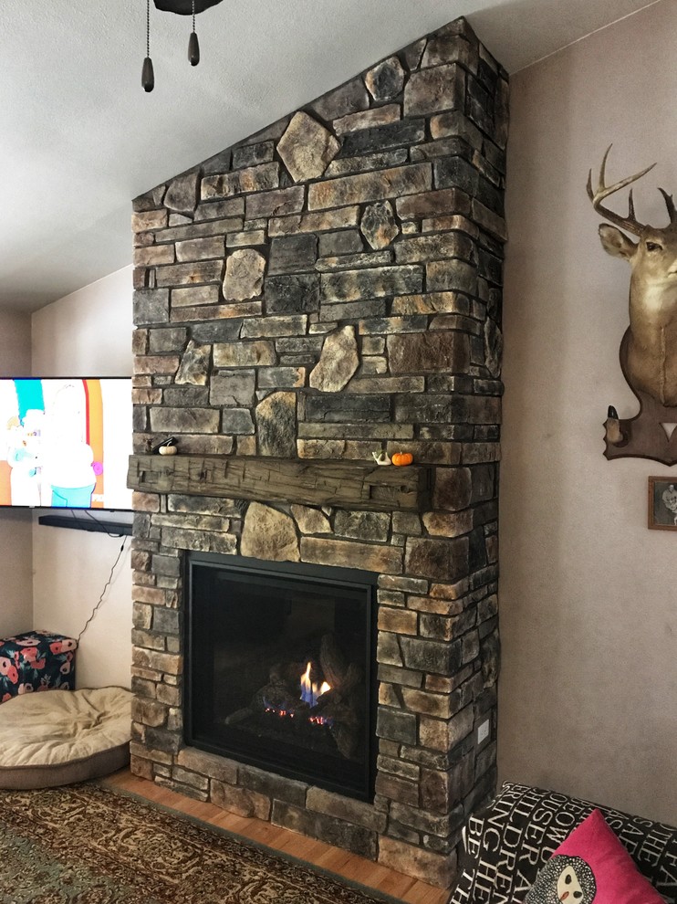 Foto de sala de estar rural pequeña con todas las chimeneas y marco de chimenea de piedra