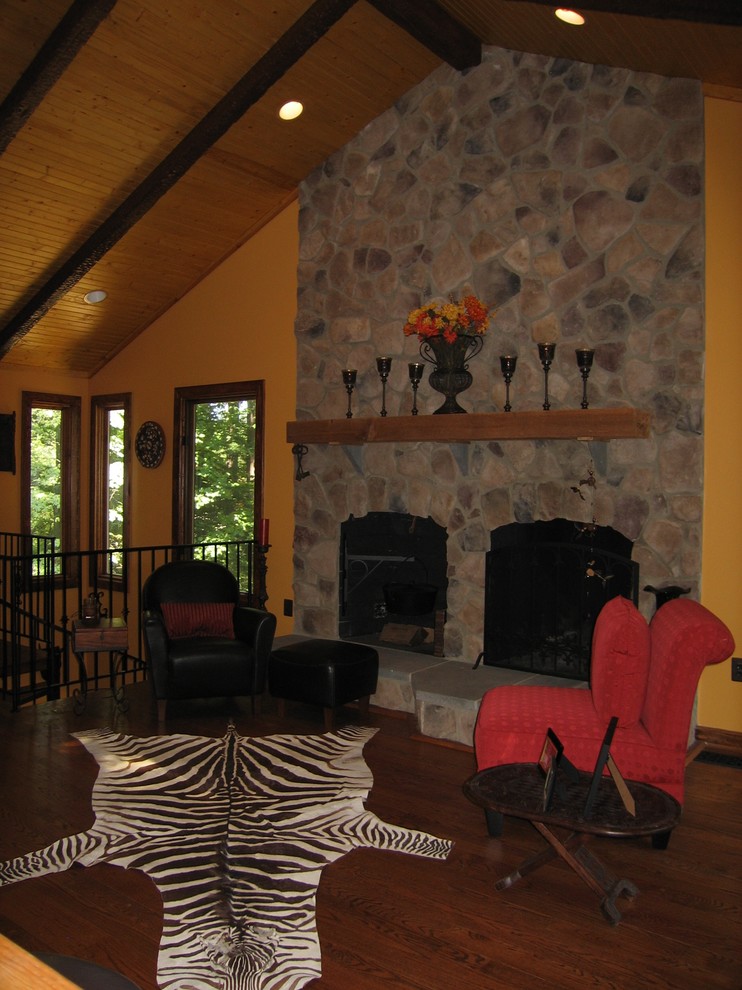Mittelgroßes, Offenes Rustikales Wohnzimmer mit gelber Wandfarbe, braunem Holzboden, Kamin und Kaminumrandung aus Stein in Washington, D.C.