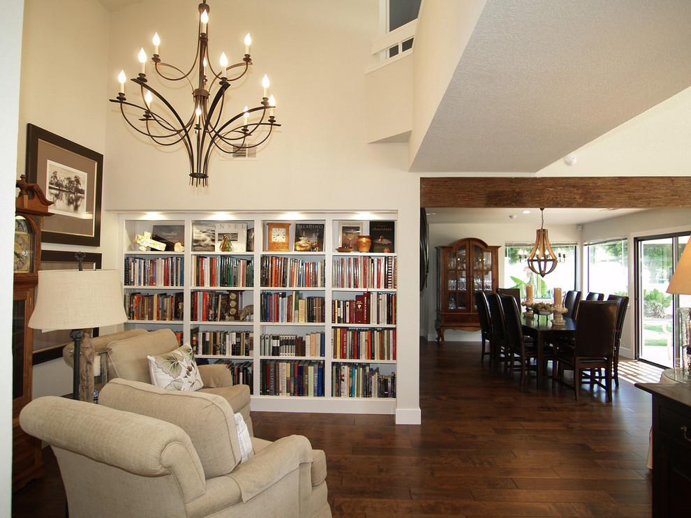 Diseño de sala de estar con biblioteca abierta rústica pequeña con paredes blancas y suelo de madera en tonos medios