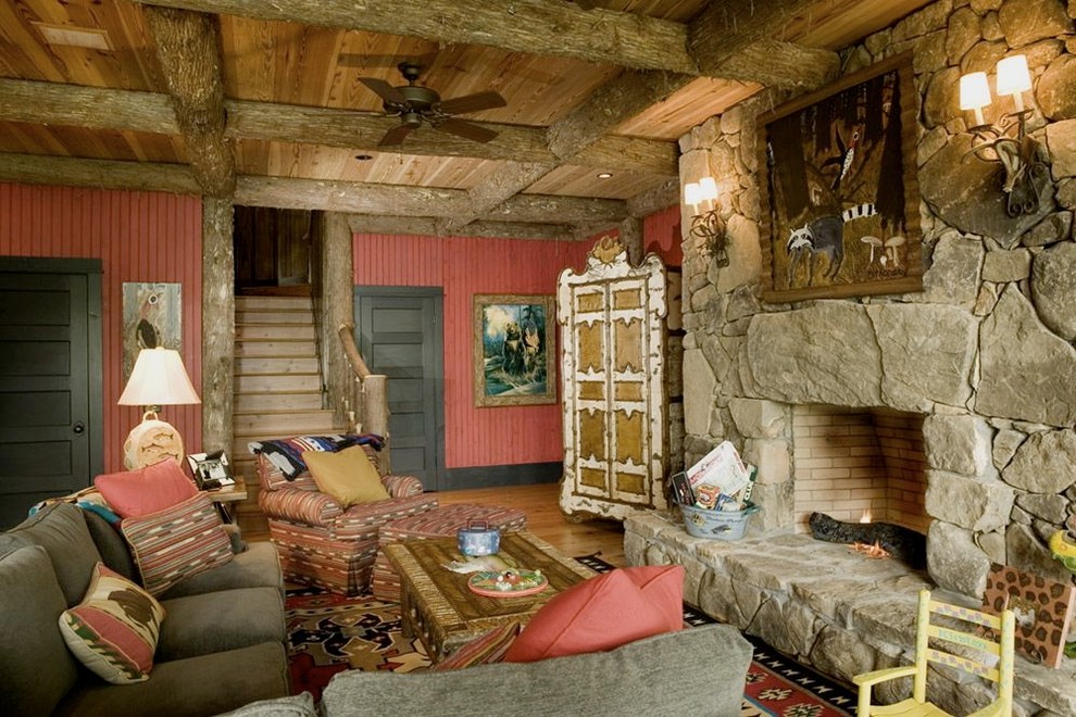 Modelo de sala de estar rústica con paredes rojas, todas las chimeneas y marco de chimenea de piedra