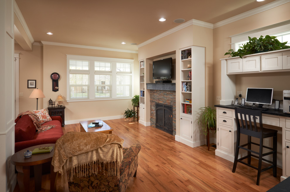 Modelo de sala de estar abierta tradicional de tamaño medio con paredes beige, suelo de madera clara, todas las chimeneas y marco de chimenea de piedra